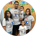 Smiling family of five wearing matching Super Mario themed t-shirts at a celebratory event.