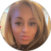 Circular headshot of a woman with long blonde hair, brown eyes, and a neutral expression.