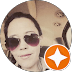 Woman wearing dark sunglasses in a circular profile photo with an orange star badge.